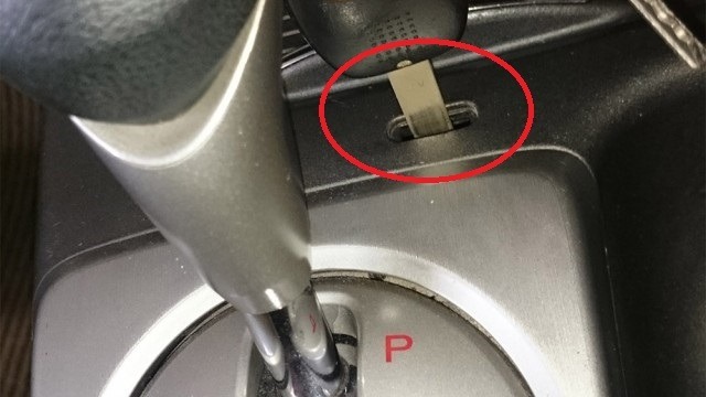 The Automatic Transmission Unlock Latch is usually located next to the gear lever.